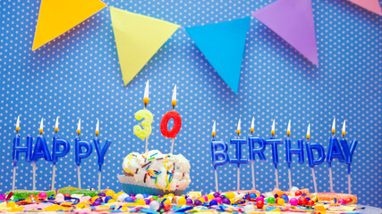 Word from letters of happy birthday candles for thirty years. Copy space Happy birthday greetings for 30 years, lit candles with holiday decorations. Beautiful holiday card