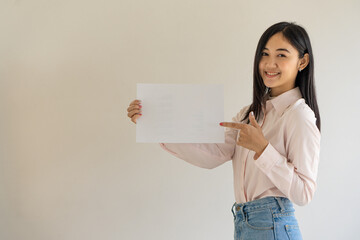 Asian woman holding blank paper with smiling face and white background for inserting text or...