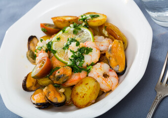 Image of delicious warm salad of shrimps, mussels and fried new potatoes