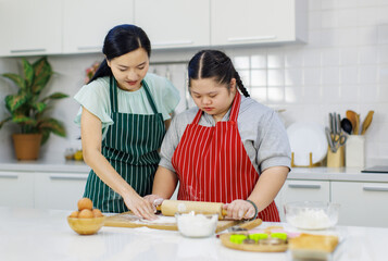 Asian lovely mother encouraging teaching young chubby down syndrome autistic autism pastry chef...