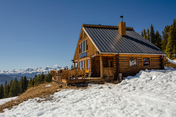 A mountain cabin set against the snowy peaks