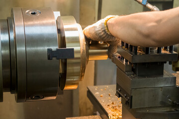 The machine operator working with brass material parts on lathe machine.