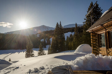 Sunrise over a snowy mountain cabin in winter
