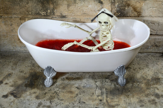 Halloween haunted house skeleton in bathtub filled with blood colored raspberry gelatin