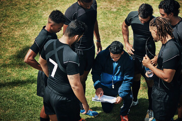 So here's the plan. High angle shot of a handsome young rugby coach addressing his team on the...