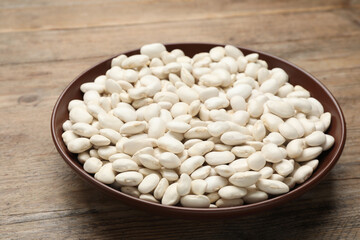 Raw white beans on wooden table, closeup