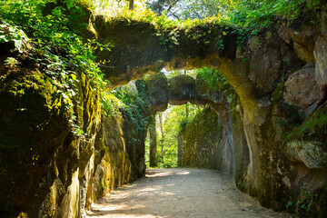 Picturesque alley with stone arches in park of Quinta da Regaleira, Sintra, Portugal