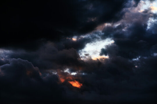 Dreamy dark sky with black, purple and orange sunset clouds, horizontal design background, stylish website backdrop