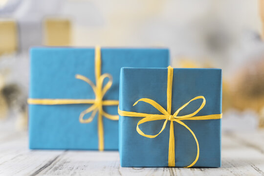 festive background with two gift boxes wrapped in blue paper and tied with yellow ribbon