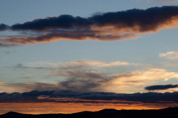 Lush, heavy clouds, painted orange by the sun at sunset. Texture.