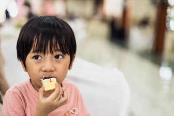 Cute little boy is eating cake 
