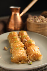 Delicious baklava with pistachio nuts on table, closeup