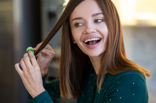 Smiling young woman demonstrating hairstyling tips