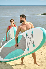 Obraz premium A happy couple with kayaks on a beach