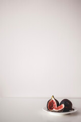 Fresh figs on the plate on grey background. Two figs minimalism.