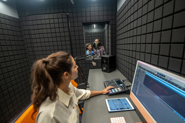 Studio technician lowering the volume level on the mixing console