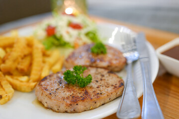 Pork Steak with Pepper Sauce and fries on wooden table.