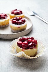 Mini cheesecake with cherry jam. One bite dessert. Tiny cheesecakes with berry. Valentine homemade present. Selective focus.