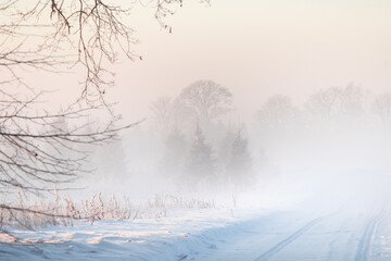 A beautiful snowy sunrise landscape with a road. Winter morning scenery of Northern Europe.