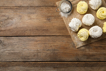 Delicious white and yellow marshmallows on wooden table, flat lay. Space for text