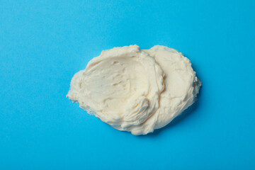 Smear of delicious cream cheese on light blue background, top view