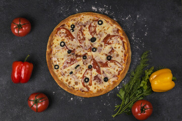 pizza with tomatoes on dark table