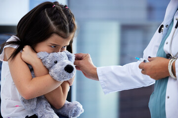 I'd rather be at the park. Shot of a scared little girl getting a vaccination in a hospital.