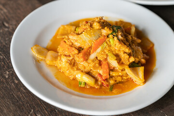 Close up stir-fried Crabmeat with curry powder and egg, healthy seafood Thai food on wooden table, natural light.