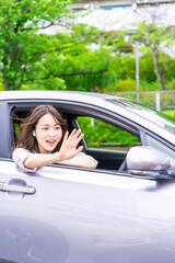 運転席から顔を出す若い女性