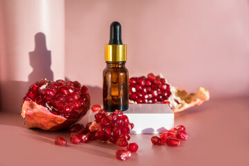 Composition with natural cosmetic oil and pomegranate on light background