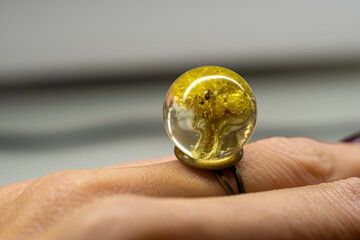 Dwarf everlast ring on a finger. Sphere ball made of epoxy resin with natural dried flowers inside....
