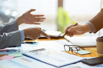 A businesspeople working on financial report together on the desk.