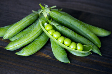 Pods of green peas on a dark background. Seasonal products. Products from local producers. Vegetarianism. copy space. Close-up. Selective focus. - 481307419