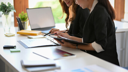 Colleagues working on online project together in the office.