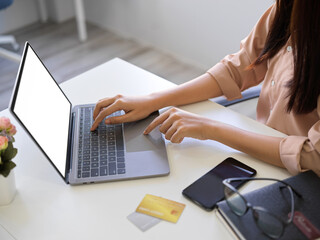 Close-up image of a businesswoman typing on laptop keyboard.