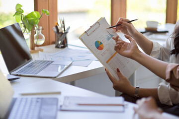 Financial analysts team recheck their financial report paperwork.