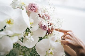 Fototapeta premium 白い花束を触る女性の手
