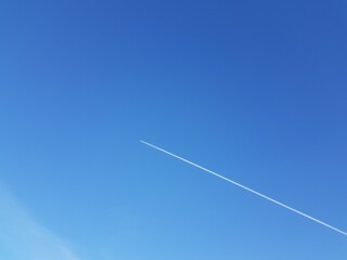 White trail from an airplane in the blue sky