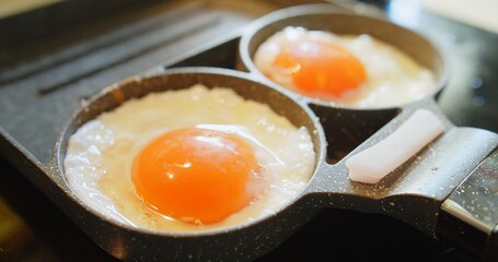 Close up Cooking Scrambled Eggs Fried Eggs on the Stove in a Frying Pan for breakfast food, The Concept of Protein Healthy Food and Diet	
