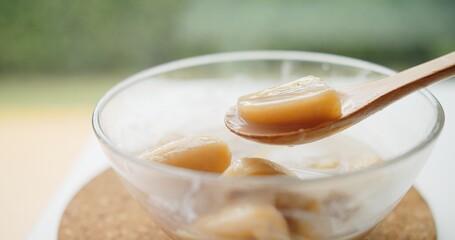 Close up wooden spoon holding Thai traditional sweet dessert food banana in coconut milk, Thai Cuisine	
