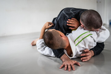 Two brazilian jiu jitsu bjj figters martial arts training male athlete practice technique or...