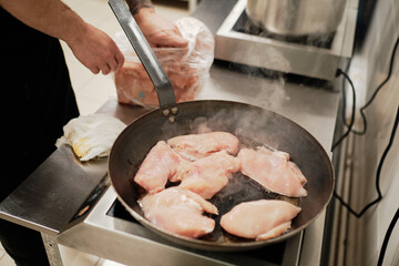Chef frying chicken on the pan