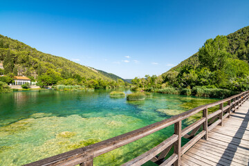 Obraz premium Waterfalls at Skradinski Buk, national nature park Krka, Croatia. Flowing water in beautiful nature, green plants and trees. Sunny summer day.