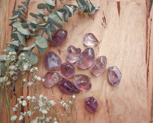amethyst purple crystal tumbled semi precious stone, senitransparent rock, on raw natural wood with...