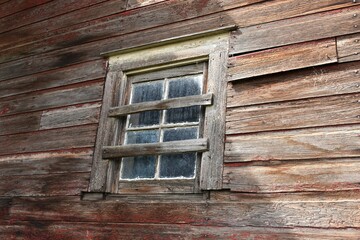 Dirty window in weathered, old, abandoned wooden barn. 