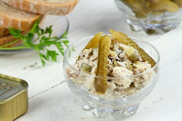 Bowl of fresh pate decorated with cut pickles.  Slices of bread, tin of sardines, bowl of pickles and parsley around.