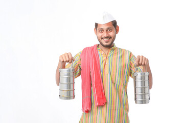 Young indian common man in traditional wear holding tiffin box in hand on white background.