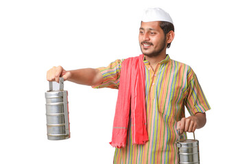 Young indian common man in traditional wear holding tiffin box in hand on white background.