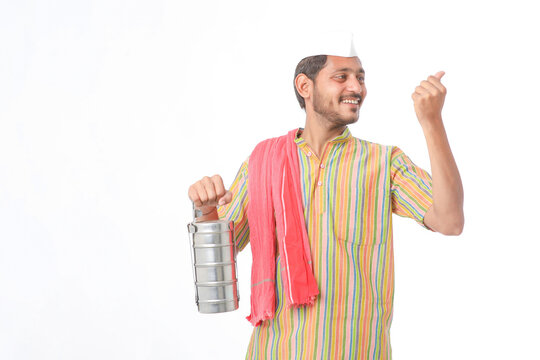 Young indian common man in traditional wear holding tiffin box in hand on white background.