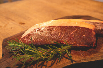 raw beef steak, fresh uncooked cut meat with rosemary and pepper, butcher with fillet sirloin or...